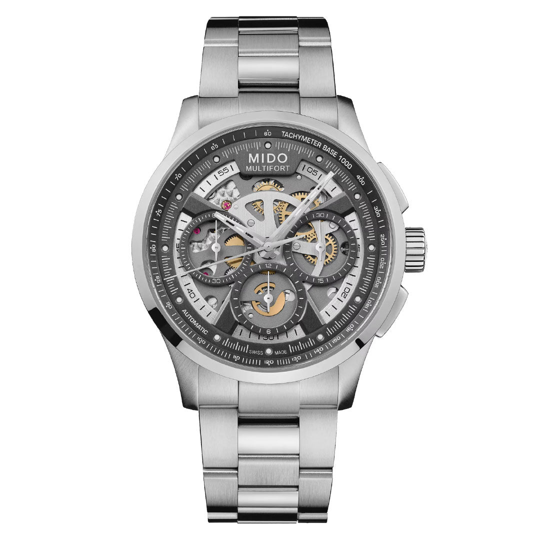 The MIDO Multifort Skeleton Chronograph Automatic 43mm Watch features a stainless steel case, silver metal band, skeleton dial with exposed gears, multiple subdials, tachymeter markings, and Swiss automatic movement.