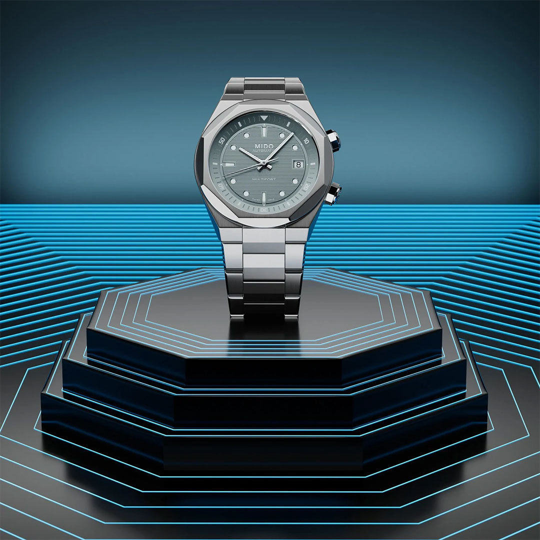 A MIDO Multifort 8 Two Crowns Automatic 40mm watch is showcased on a black octagonal pedestal, encircled by glowing blue neon lines set against a dark, futuristic background.