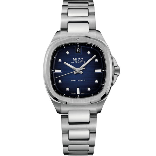 The MIDO Multifort TV 35 Automatic 35mm Watch features a blue dial with silver hour markers, a date display at 12 o’clock, automatic movement, a brushed metal bracelet, and a round-edged square stainless steel case.