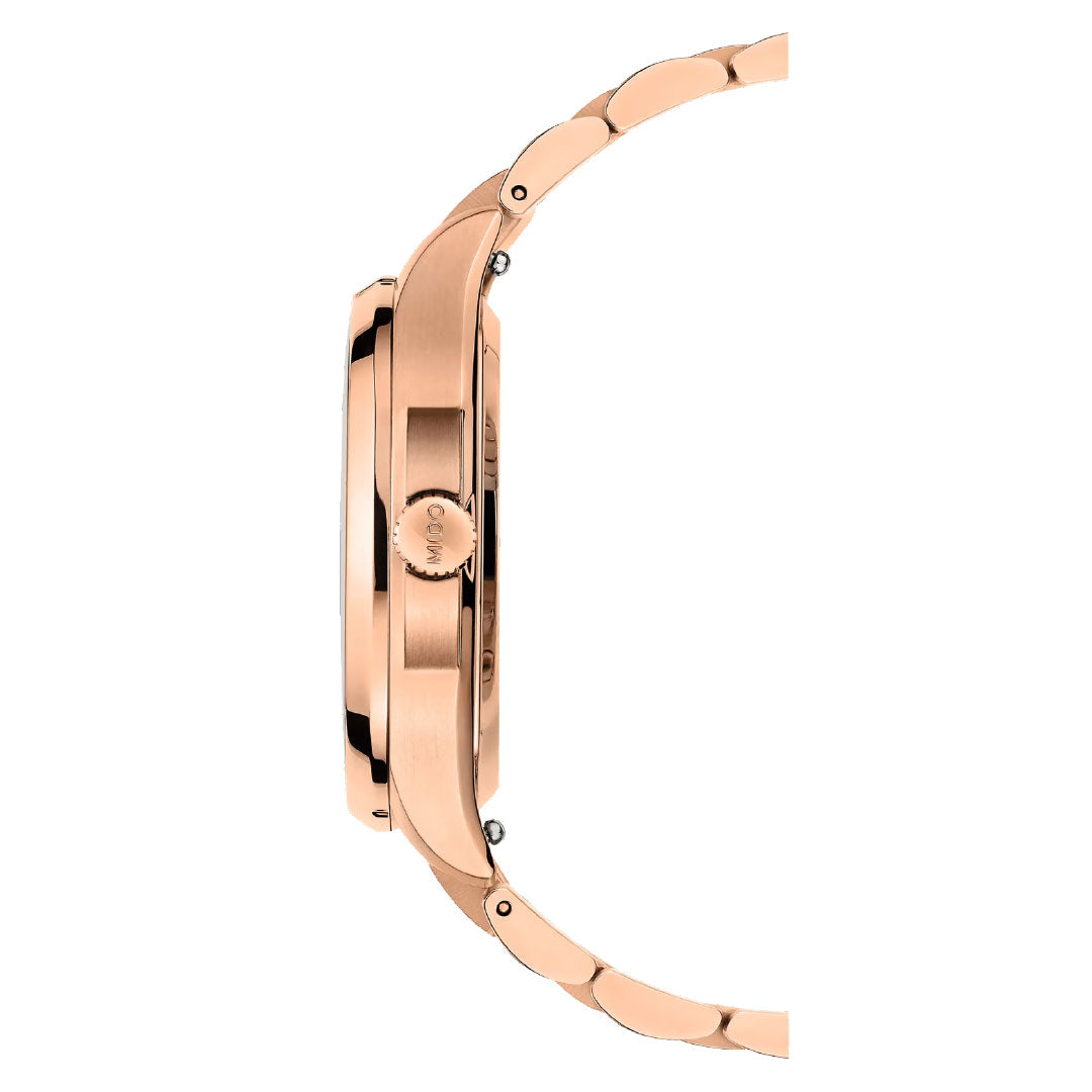 Side view of the MIDO Multifort TV 35 Automatic 35mm Watch in rose gold with a metallic link band and round crown, showcasing its case details and automatic movement, set against a white background.