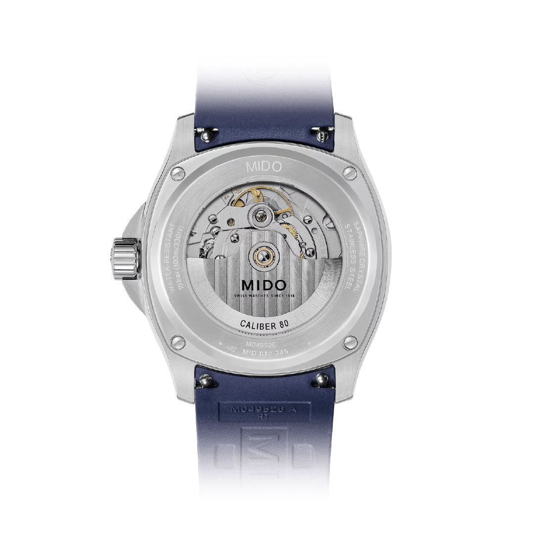The back of the MIDO Multifort TV Big Date Automatic 40mm Watch reveals its automatic movement through a transparent case, highlighting the mechanics and "Caliber 80" engraving. It features a blue strap and a sleek silver back.