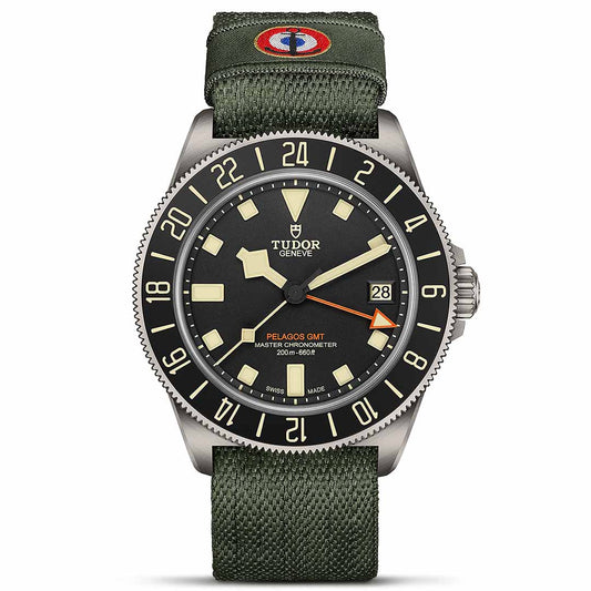 The TUDOR Pelagos FXD GMT showcases a black dial with luminous markers and an orange GMT hand for accurate Zulu timekeeping. It is equipped with a date display at the 3 o'clock position and comes with a green NATO strap featuring a circular blue and red emblem inspired by French Naval Aviation. This watch also offers water resistance up to 200 meters.