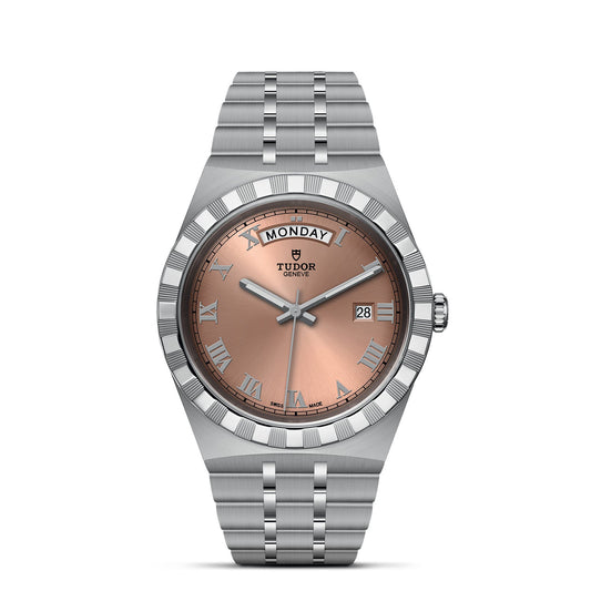 The TUDOR Royal is a luxury timepiece with a stainless steel bracelet and a round brown dial featuring a sunburst effect. It includes Roman numeral hour markers, a day display at the top, and a date window at the 3 o'clock position. The brand name, TUDOR, is elegantly positioned beneath the day display.
