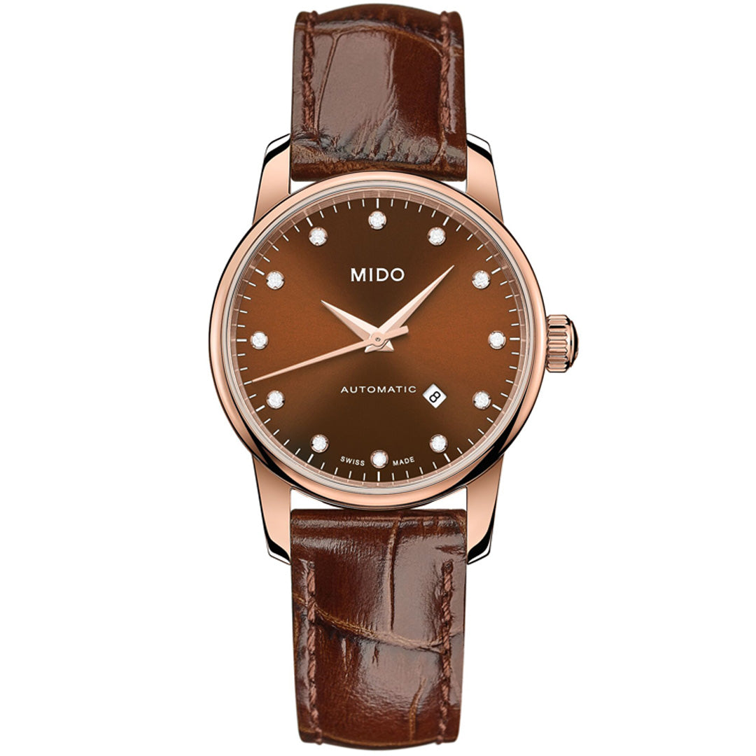 The MIDO Baroncelli II Lady Automatic 29mm features a brown leather strap, rose gold case, brown dial with diamond markers, automatic movement, date at 6 o’clock, and three hands.