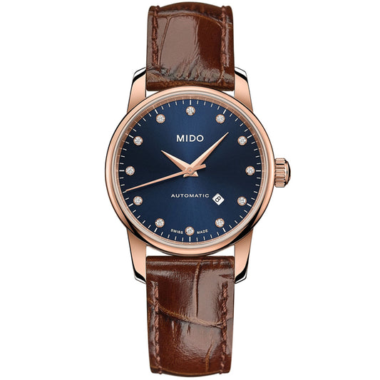 The MIDO Baroncelli II Lady Automatic 29mm features a dark blue dial, gold-tone case, diamond hour markers, brown leather strap, Caliber 80 movement, date display, plus "AUTOMATIC" and "SWISS MADE" on the dial.
