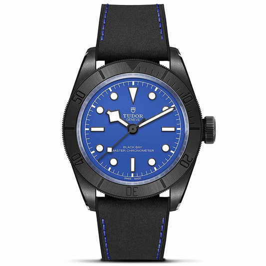 The TUDOR Black Bay Ceramic is a stylish timepiece featuring a bold blue dial complemented by a black rotating bezel with luminous markers, all housed in a sleek ceramic case. It is paired with a black strap enhanced by blue stitching and prominently displays the "TUDOR" branding. The watch showcases time through its elegant hour, minute, and second hands.