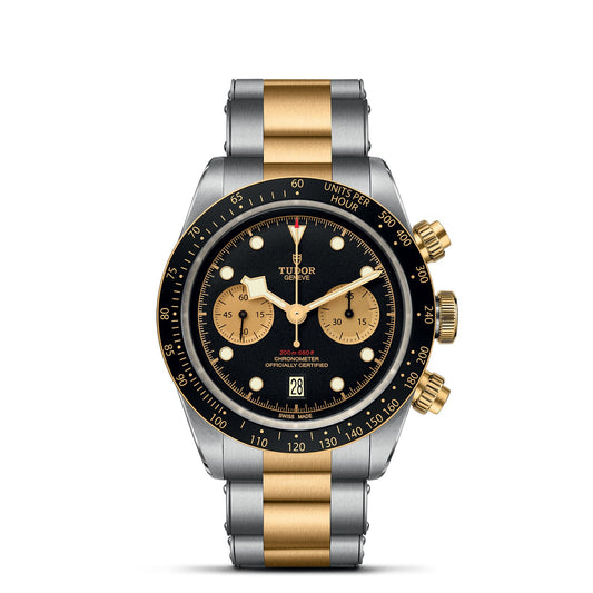 The TUDOR Black Bay Chrono S&G is a luxury wristwatch featuring a black dial complemented by gold accents. It comes with a stainless steel and gold bracelet. This exquisite timepiece includes three subdials, a date window, and a tachymeter bezel, with the TUDOR brand name and details elegantly displayed on the face.