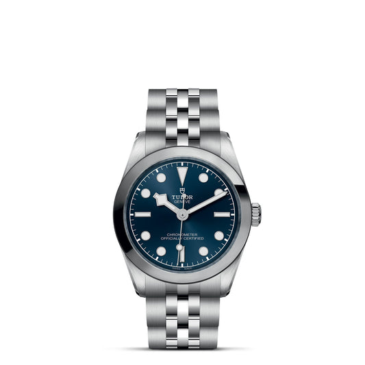 The TUDOR Black Bay One 31 features a silver metal wristwatch with a deep blue dial, white hour markers, three hands, and a date window. It has a five-link bracelet and sleek steel case inspired by TUDOR divers' watches, proudly displaying the TUDOR brand name.