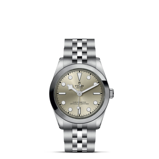 The TUDOR Black Bay One 31 wristwatch features a stainless steel bracelet, silver dial with date window and luminous markers, highlighted by a smooth bezel and sleek silver hands, along with the iconic crown logo, reflecting its minimalist elegance.