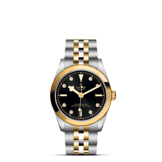 The TUDOR Black Bay One 31 S&G is a luxury wristwatch with a black dial, diamond hour markers, and mixed gold and silver on the bezel and strap. It features TUDOR branding beneath a crown logo on its exquisite steel and yellow gold bracelet.