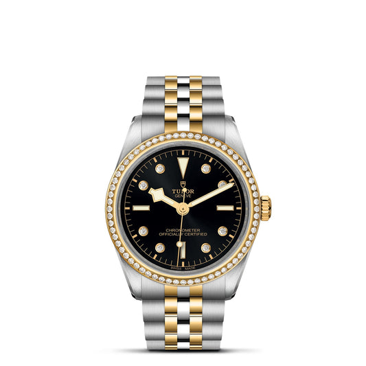 The TUDOR Black Bay One 36 S&G wristwatch features a 36mm steel case, black dial, and a gold and silver two-tone bracelet. Diamond accents adorn the bezel, with sleek gold hands over gold hour markers accented by round diamond details.