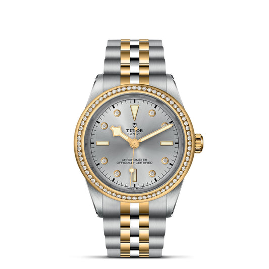 Indulge in the sophistication of the TUDOR Black Bay One 39 S&G, featuring a 39mm steel case, elegantly paired with a silver and gold two-tone bracelet and bezel. The silver dial is adorned with gold hour markers, hands with diamond accents, and bears the TUDOR brand name and logo.