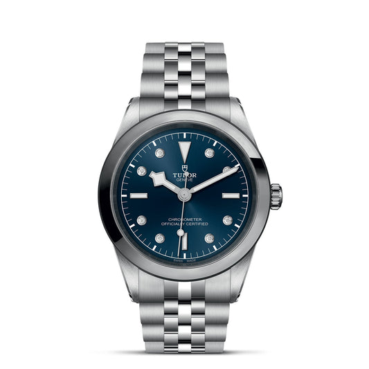 The TUDOR Black Bay One 41 combines a 41mm steel case with a silver metal bracelet and dark blue dial. Inspired by TUDOR Black Bay divers' watches, it features silver hour markers, hands, and the prominent "Tudor" logo.