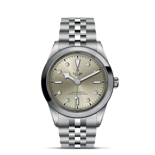 The TUDOR Black Bay One 41 features a silver design, light champagne dial with diamond hour markers, and silver hands in a refined 41mm steel case. The coordinated bracelet enhances its elegance, while "Tudor" and "Chronometer Officially Certified" inscriptions emphasize its heritage.