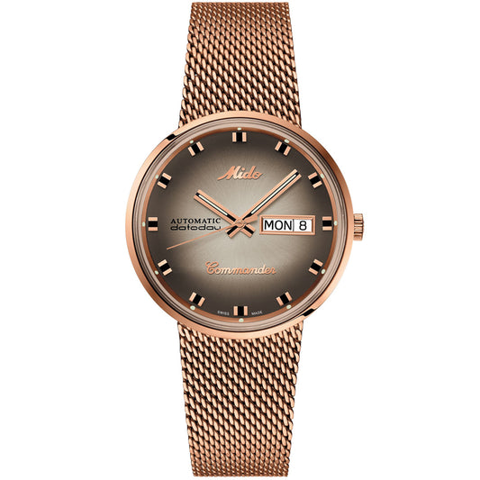 The MIDO Commander Shade Automatic 37mm Watch features a rose gold case, mesh band, brown gradient dial with day-date at 3 o’clock, gold hands and indices—blending retro style with dependable automatic movement.