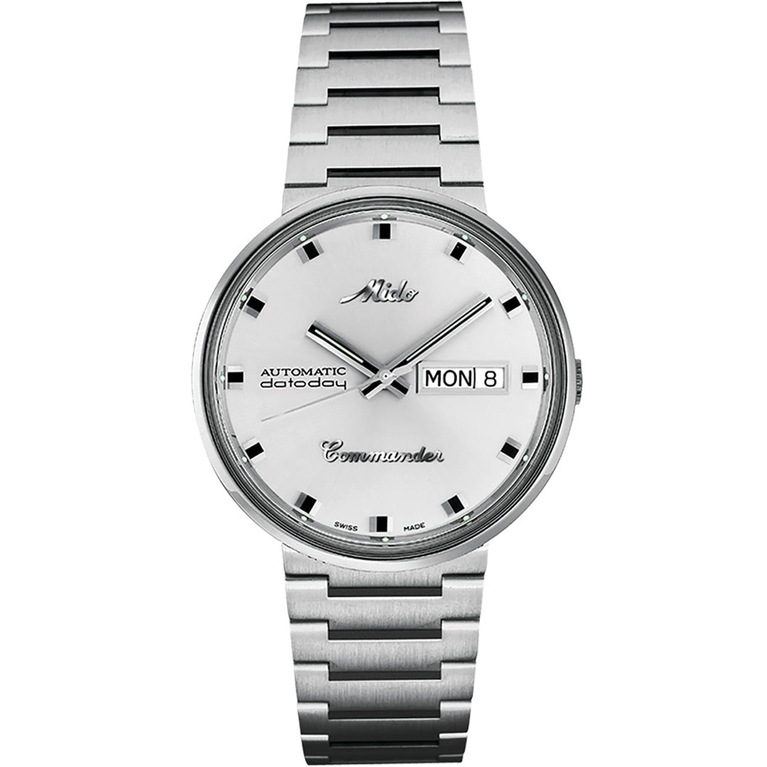 The MIDO Commander 1959 Automatic 37mm watch features a silver integrated bracelet, white dial, black hour markers, silver hands, and a day-date display on the right side.