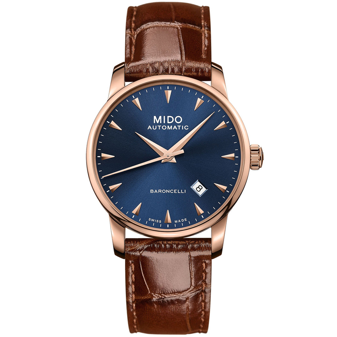 The MIDO Baroncelli II Gent Automatic 38mm features a blue dial with gold hour markers, rose gold case, brown leather strap, and date display at 3 o’clock. "MIDO AUTOMATIC" and "BARONCELLI" are printed on the dial. Powered by Caliber 80.