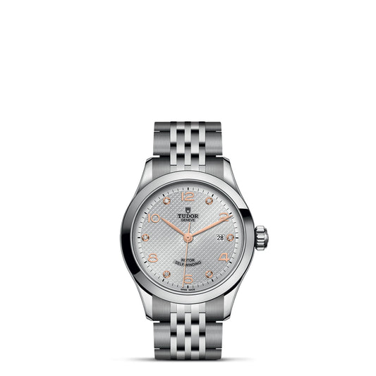The TUDOR 1926 wristwatch, crafted from stainless steel, boasts a silver dial with elegant rose gold accents. Perfect for mechanical watch aficionados, it includes a date display and a patterned bracelet strap. The Tudor logo is proudly displayed on the dial, complemented by rose gold hour markers.