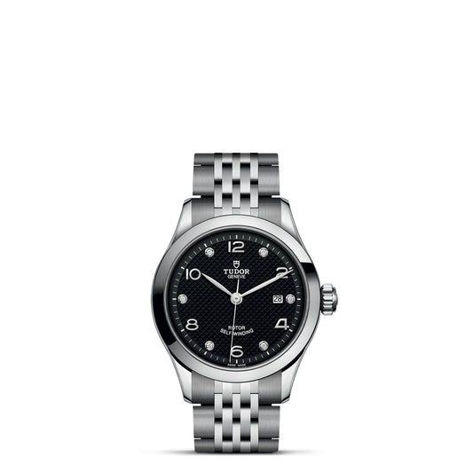 A silver wristwatch featuring a black diamond-set dial with the TUDOR logo at 12 o'clock. Reflecting the timeless elegance of the TUDOR 1926, it includes a stainless steel bracelet, Arabic numerals, and a date display at 3 o'clock—ideal for enthusiasts of mechanical timepieces.