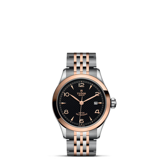 The TUDOR 1926 watch from TUDOR showcases a black dial accented with rose gold, paired with a silver and rose gold metal bracelet. This sophisticated timepiece is highlighted by its stunning rose gold bezel and includes a date window, luminous hands, and hour markers.