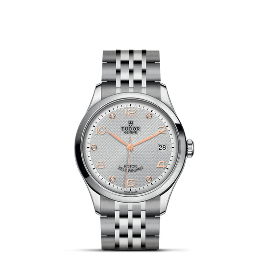 The TUDOR 1926 is an elegant wristwatch featuring a white diamond-set dial, gold Arabic numerals, and gold-toned hands. It comes with a sophisticated silver case and stainless steel bracelet. The watch showcases the Tudor logo, a date display at 3 o'clock, and is inscribed with "Tudor Geneve" and "Rotor Self-Winding," celebrating its mechanical watch allure.