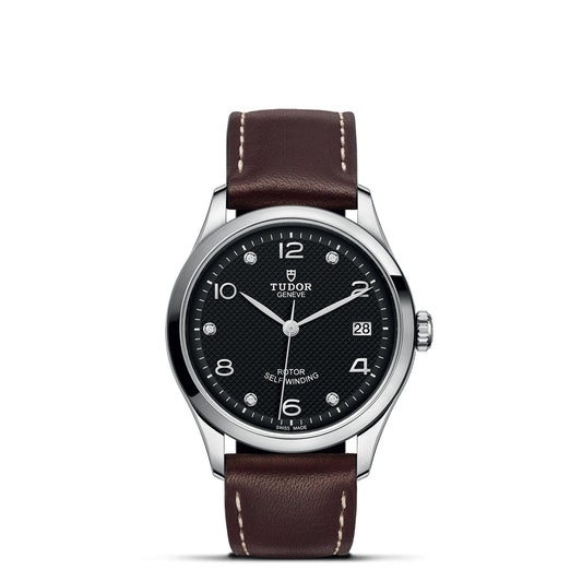 The TUDOR 1926 watch, crafted in a silver tone, features a diamond-set black dial complemented by white hour markers and the TUDOR logo. Its sophisticated design includes a date display and is paired with a brown leather strap, exemplifying the elegance of mechanical watches.