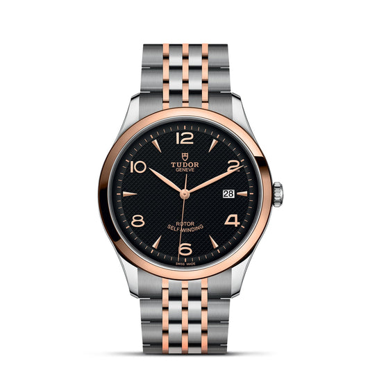 The TUDOR 1926 luxury wristwatch showcases a round black dial with rose gold hour markers, all beautifully encased in stainless steel and rose gold. It includes a date display and features a two-tone metal link bracelet, capturing the elegance of mechanical watches.