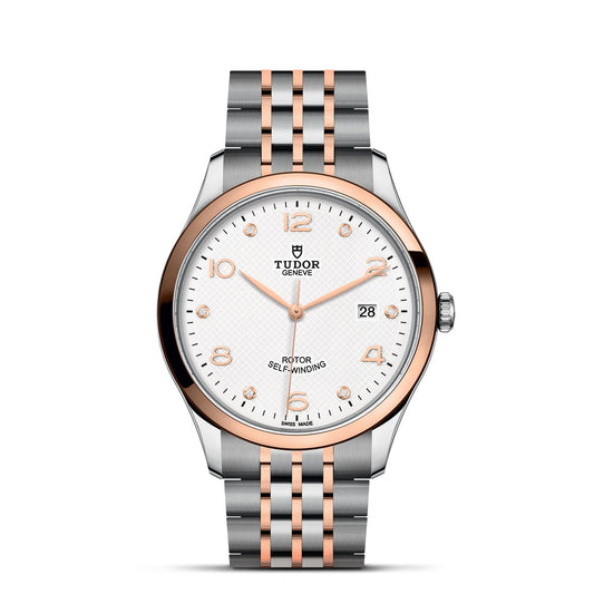 Experience the refined sophistication of the TUDOR 1926 wristwatch, highlighted by its silver and rose gold metal strap and casing. The white dial is adorned with gold hour markers, hands, and a date window positioned at 3 o'clock. Finished with "Tudor Geneve Rotor Self-Winding," this timepiece is perfect for enthusiasts of mechanical watches.