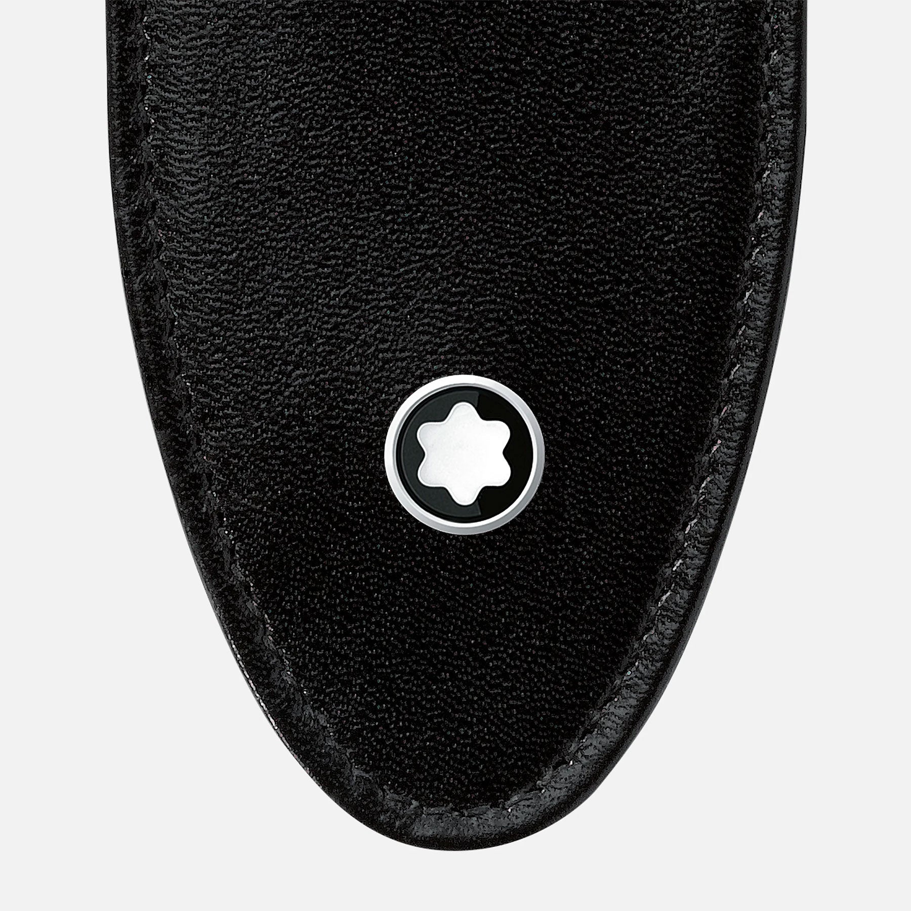 The close-up highlights the Montblanc Meisterstück Soft Grain Leather Pen Pouch, showcasing its black leather design with a rounded tip. A circular metal emblem featuring a white six-pointed star is centrally displayed against a plain white background.