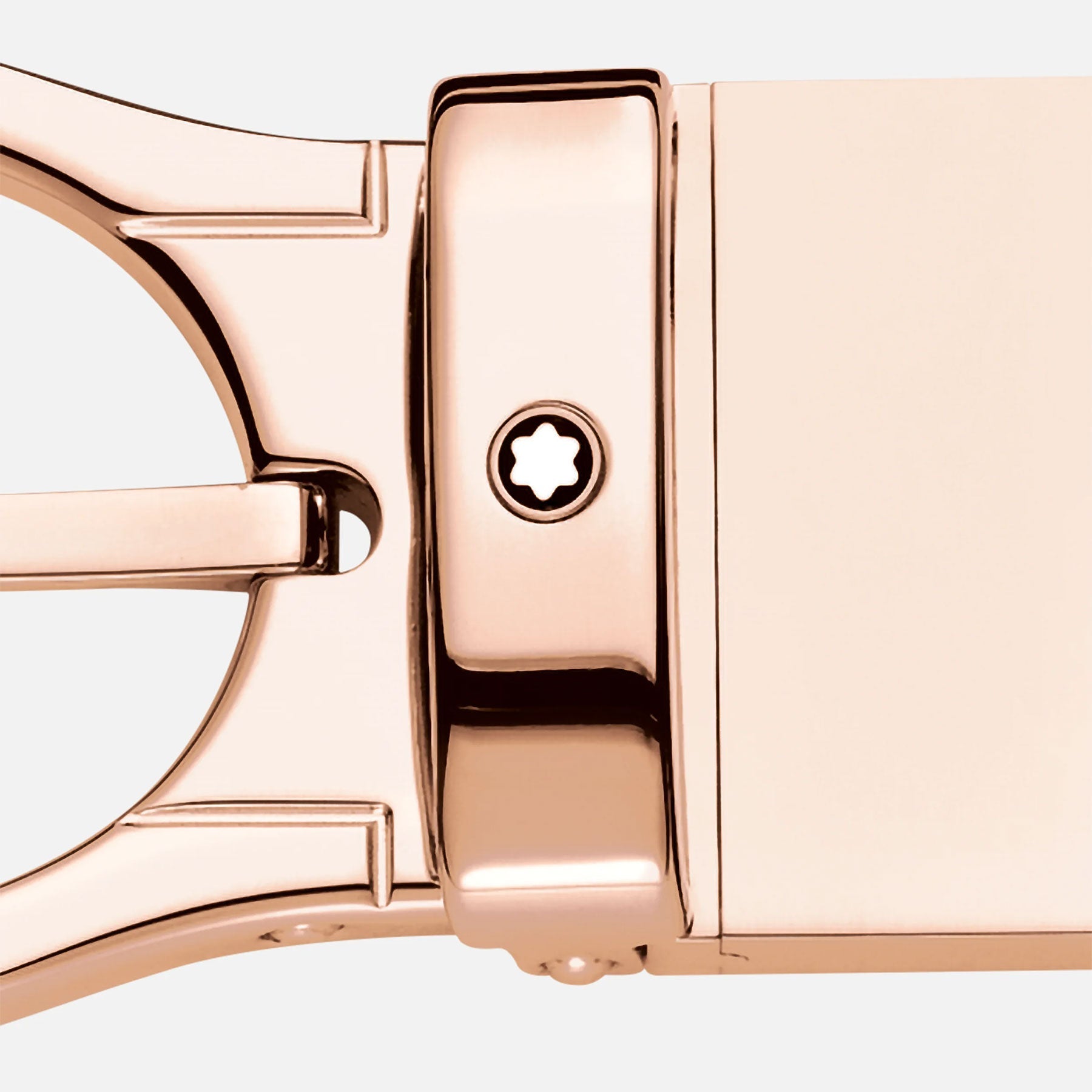Close-up of the Montblanc Reversible Black/Brown Leather Belt featuring an oval shiny rose-gold finish pin buckle. The design includes a central star-shaped screw and geometric structures, all set against a plain light gray background.