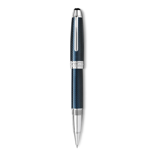 The Montblanc Meisterstück Solitaire Blue Hour Legrand Rollerball Pen features a luxurious hexagon-patterned blue and silver barrel, accentuated with silver details and designed with a fine-point nib, elegantly positioned vertically against a white background.