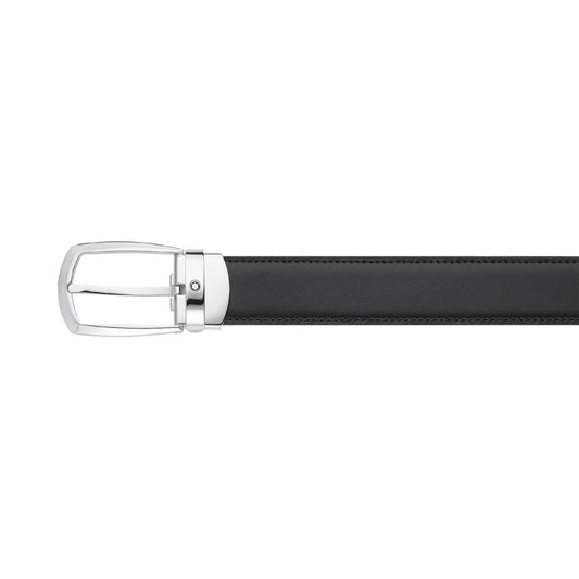 The image features a close-up of the Montblanc Reversible Black/Brown Leather Belt with a horseshoe buckle. The belt is horizontally aligned, with the buckle on the left, highlighting exquisite stitching along its edges. The sophisticated design accentuates the polished metal and smooth leather finish.