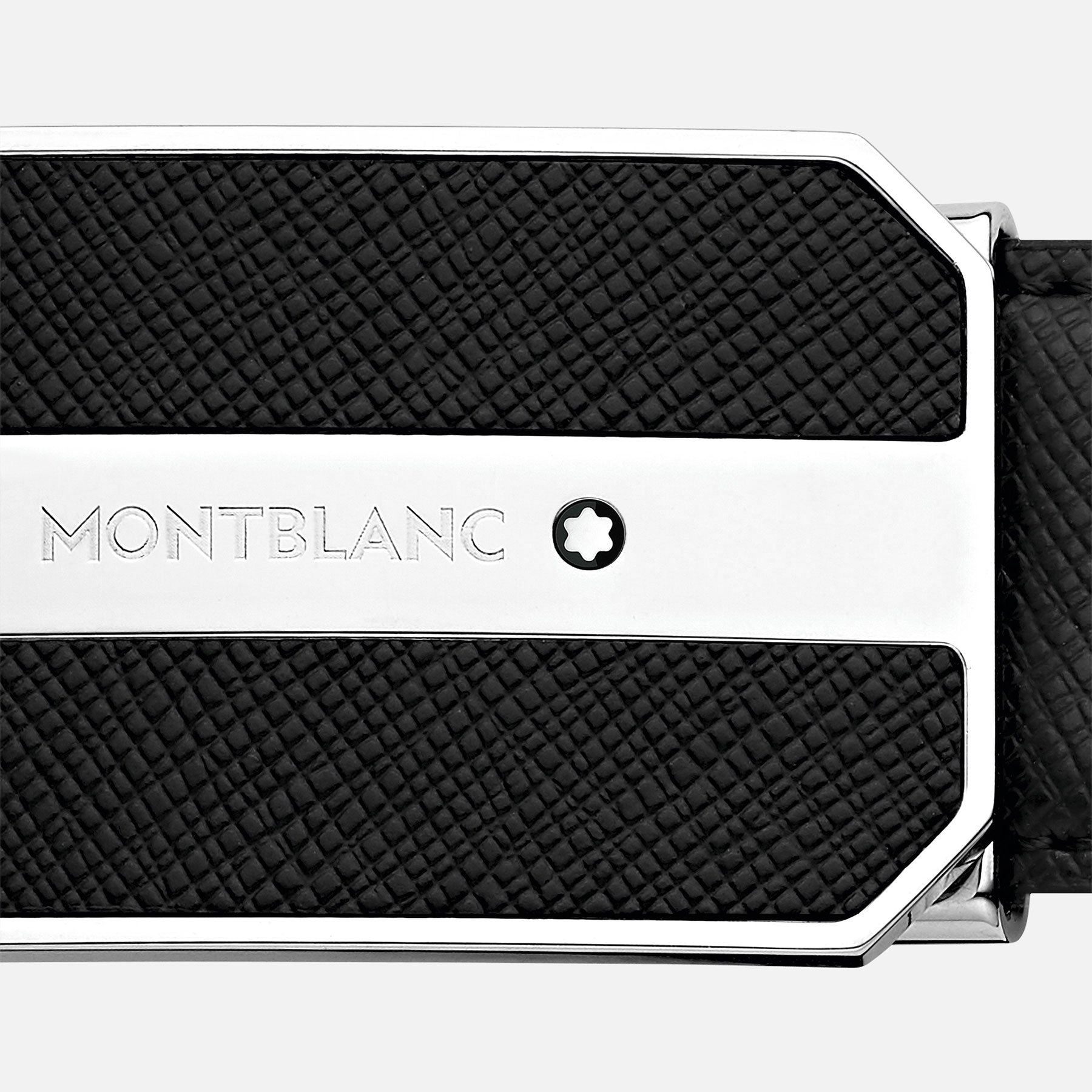 Close-up of a Montblanc Business Leather Belt buckle. The silver buckle includes a black textured rectangular panel made from Saffiano leather. The Montblanc logo and name are elegantly engraved on it, set against a plain white background.