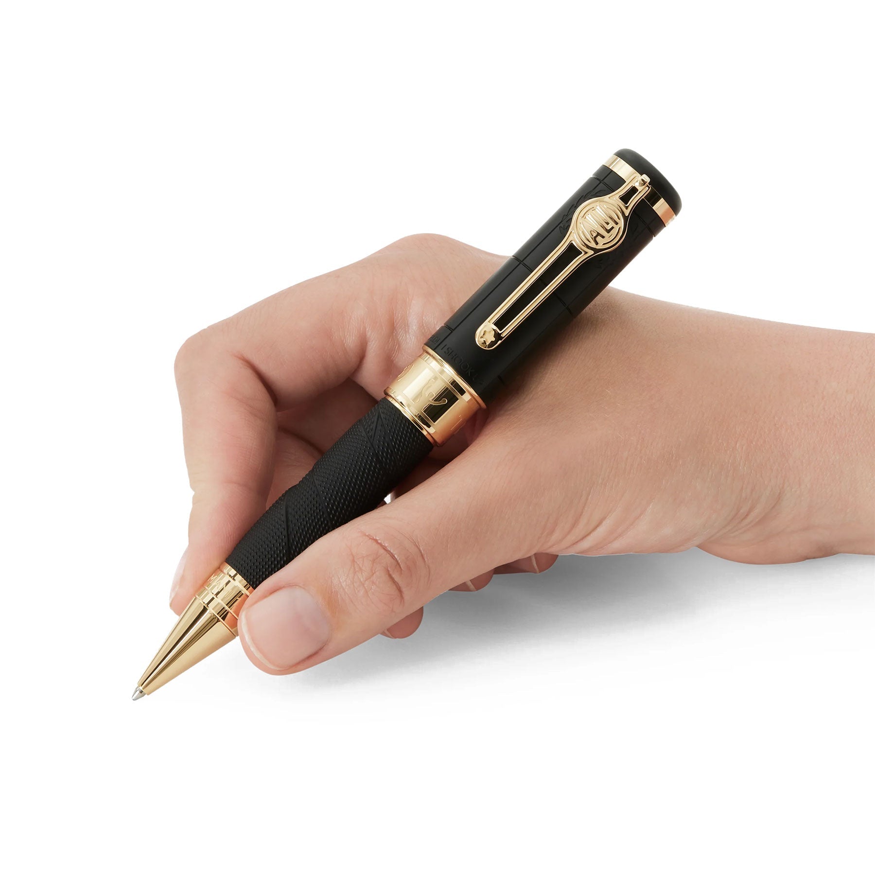 A hand holding a Montblanc Great Characters Muhammad Ali Special Edition Ballpoint Pen with intricate clip and cap detailing, poised as if about to write. The luxurious design and metallic accents mirror the elegance and precision reminiscent of a Heavyweight Champion stepping into the boxing ring.