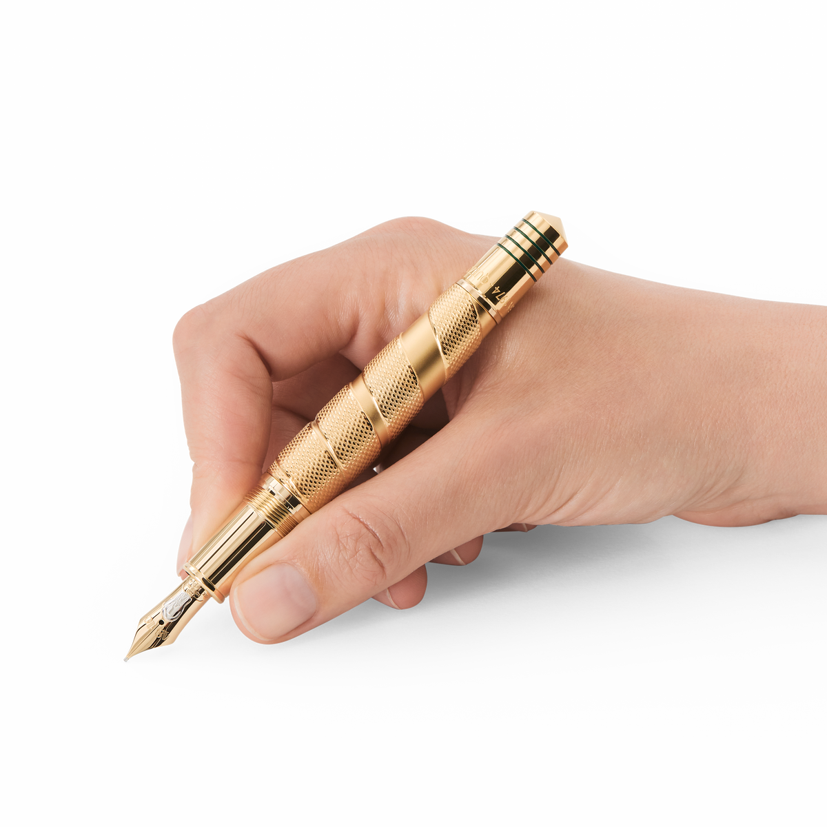 A hand holds a Montblanc Great Characters Muhammad Ali Limited Edition 1942 Fountain Pen, featuring a gold, knurled barrel and a two-tone nib.