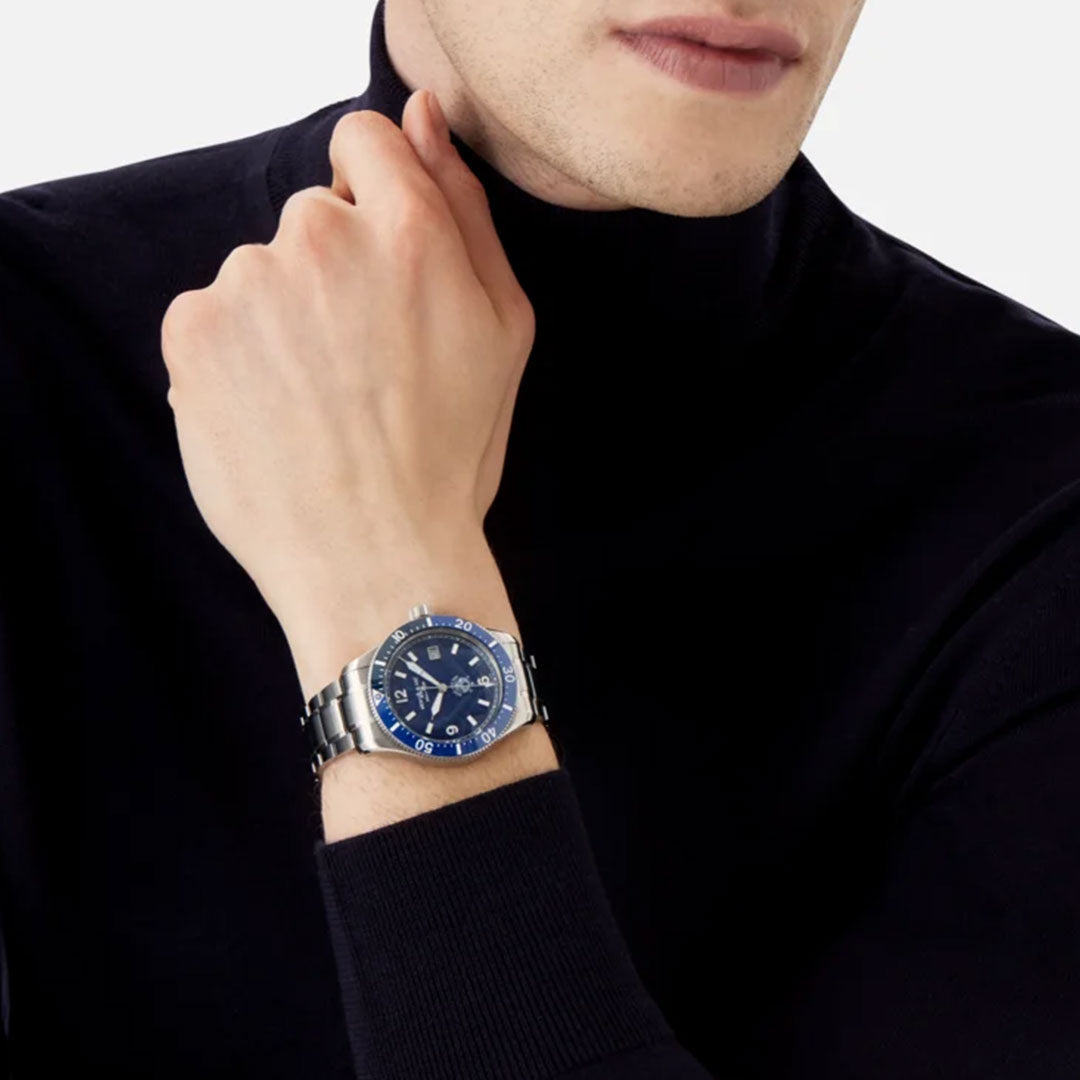 A person in a black turtleneck rests their chin on their hand, showcasing a Montblanc Iced Sea Automatic 41mm Watch with a captivating glacier pattern dial and silver bracelet. The watch's modern design complements the minimalist style of the outfit perfectly.