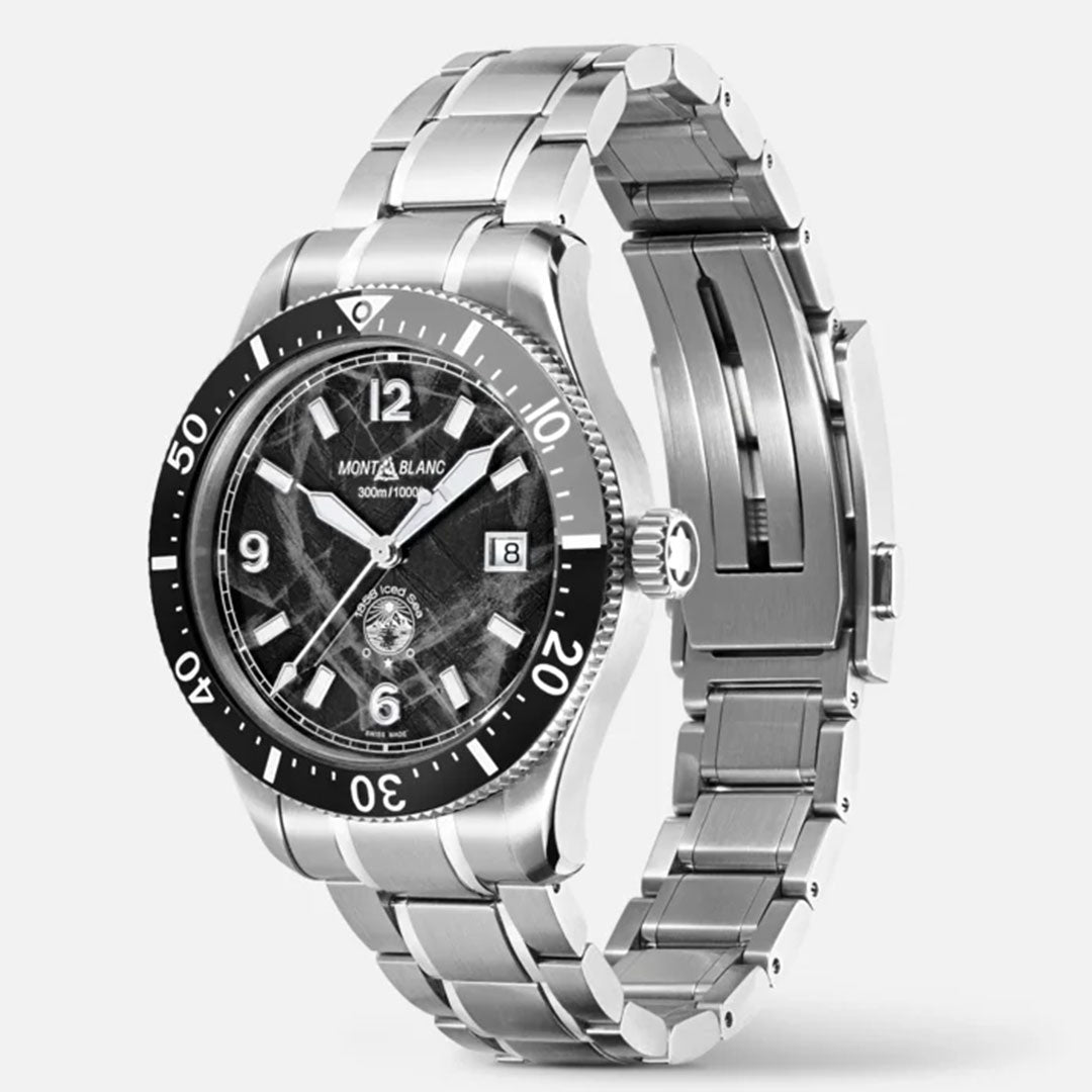 The Montblanc Iced Sea Automatic 41mm Watch, showcasing a sophisticated silver design and sporty diving features, is displayed with a metallic bracelet. It highlights a striking black glacier pattern dial accented by white numerals and hands, accompanied by a unidirectional bezel and a handy date window. The watch is artistically positioned at an angle against a light gray background.