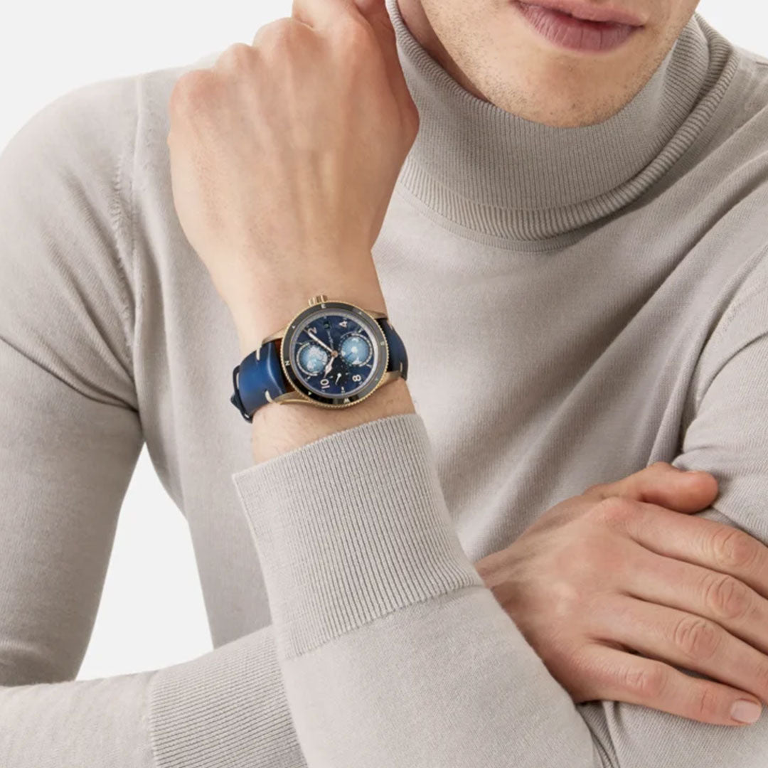 A person wearing a light gray turtleneck sweater with arms crossed, showcasing the Montblanc1858 Geosphere 0 Oxygen The 8000 Automatic 42mm Watch Limited Edition. This watch exemplifies precision over time with its immaculate design.