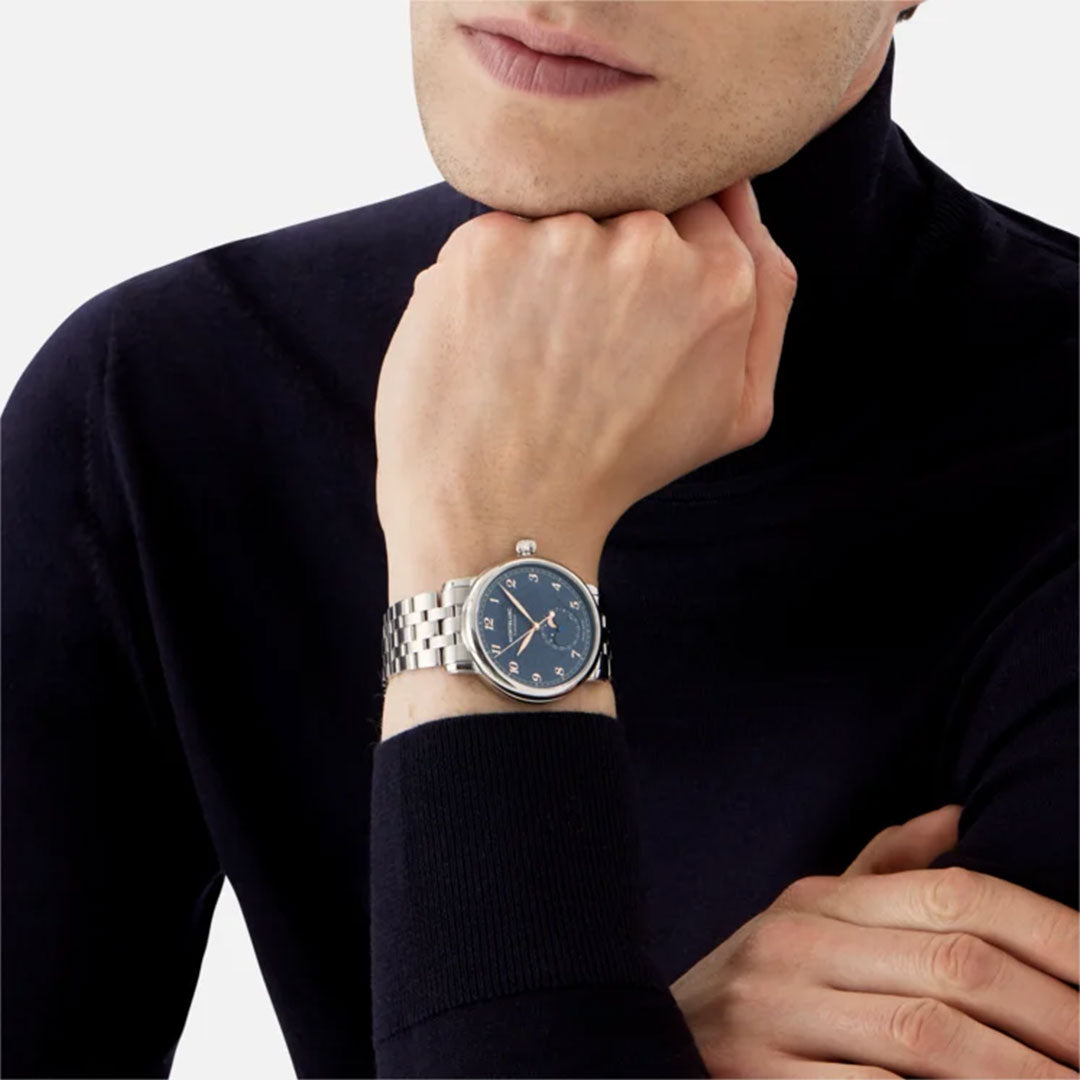 A person wearing a black long-sleeve top poses with their wrist resting on their chin, showcasing the Montblanc Star Legacy Moonphase Automatic 42mm Watch Limited Edition, featuring a silver case, blue glacier pattern dial, and metal band. The background is a plain white.