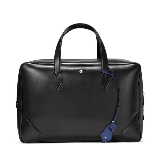 The Montblanc Meisterstück Leather Duffle Bag boasts a sleek leather design complete with short handles and a detachable blue tag. With its minimalist aesthetic, subtle stitching, and polished finish, it is ideal for travel or business use.