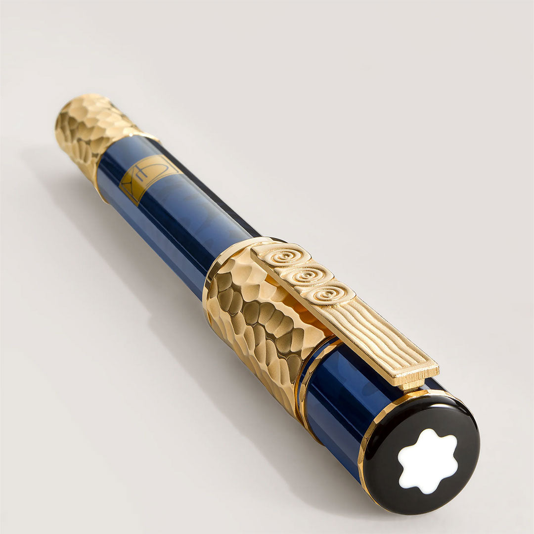 The Montblanc Masters of Art Homage To Gustav Klimt Limited Edition 4810 Rollerball Pen features a glossy dark blue barrel, ornate gold accents, and a white star emblem on the end set against black—a luxurious tribute to Klimt’s artistry.