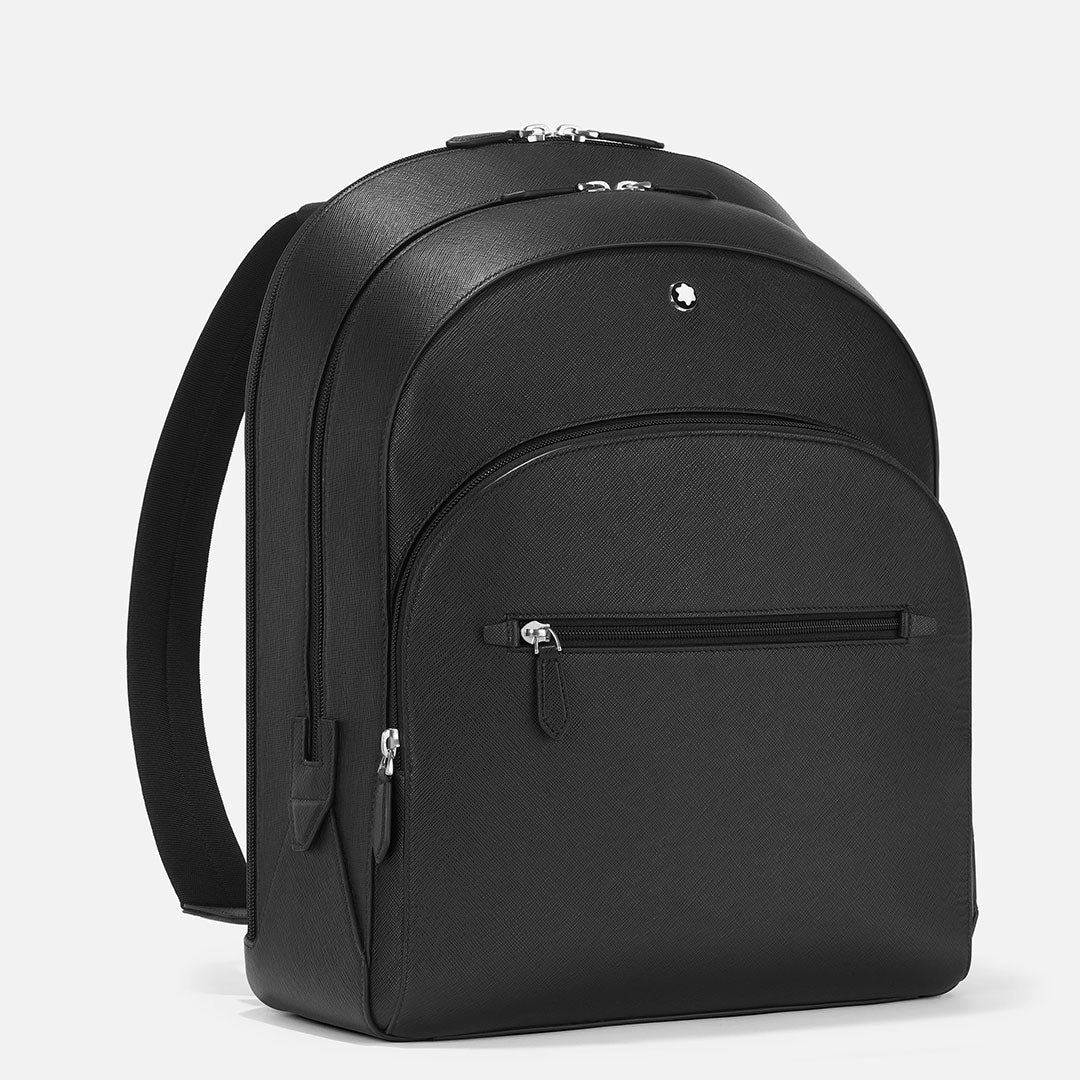 The Montblanc Sartorial Large 3 Compartments Leather Backpack Bag is a sleek black Saffiano leather business backpack with two main zip compartments, a front zip pocket, and a small silver circular logo, shown upright on a white background.