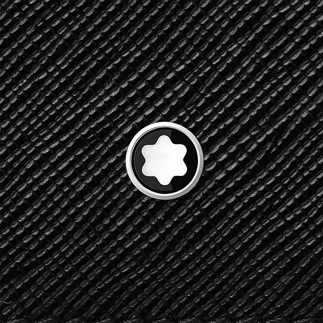 Close-up of the circular silver and black Montblanc emblem with a white star at the center, set against the textured black leather of the Montblanc Sartorial 5CC Leather Card Holder.