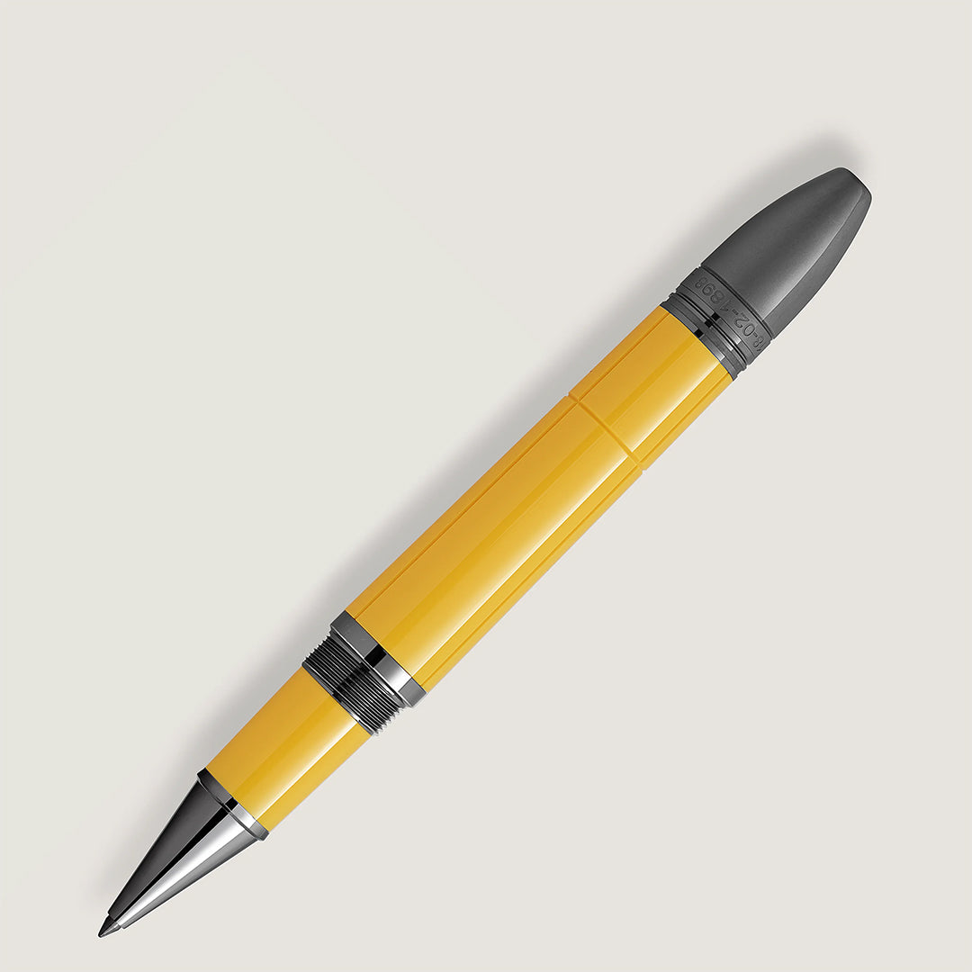The Montblanc Great Characters Enzo Ferrari Special Edition Giallo Modena Rollerball Pen is displayed diagonally on a light backdrop, showcasing its sleek yellow and gray design, modern Scuderia style, shiny barrel, and polished metallic accents.