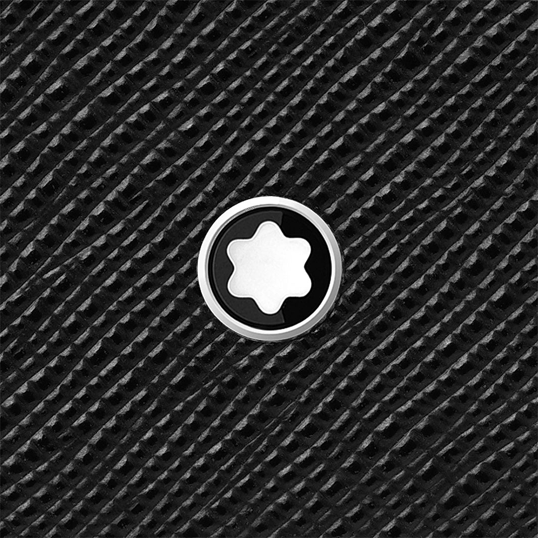 A close-up of the Montblanc Sartorial Leather Passport Holder’s textured black saffiano leather, featuring Montblanc’s signature circular emblem with a white six-pointed star—an elegant travel accessory by Montblanc.