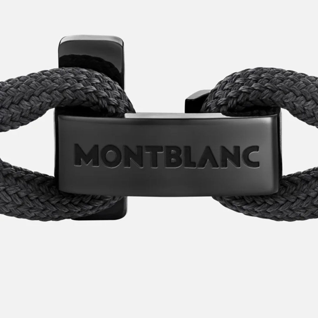Close-up of a black Montblanc T-Hook Nylon Bracelet showcasing a braided design with a sophisticated black PVD coating. The bracelet is secured by a polished clasp engraved with "MONTBLANC" against a light gray background.