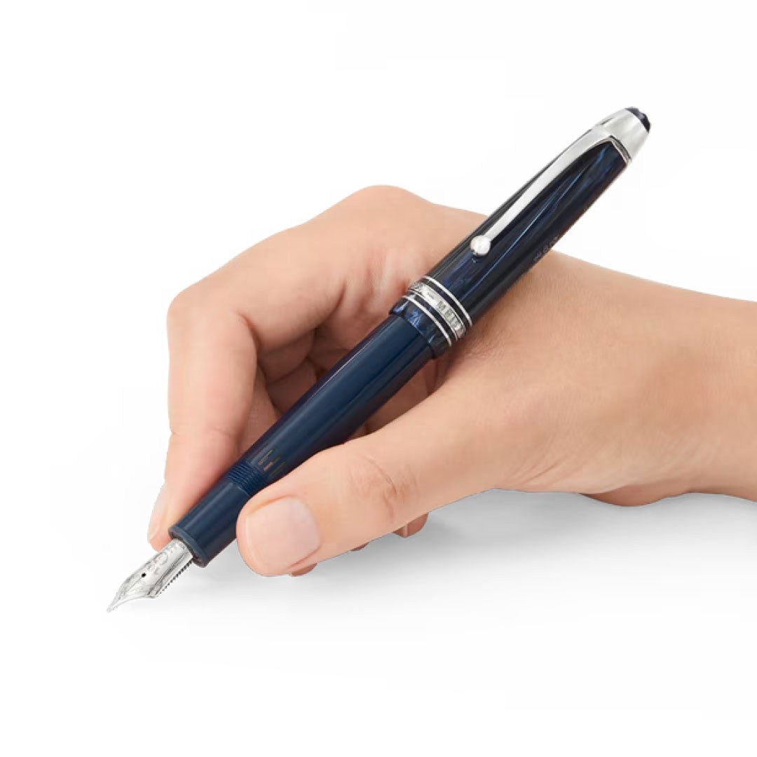 A hand holds a Montblanc Meisterstück The Origin Collection Legrand Fountain Pen M with silver accents against a white background, highlighting this elegant Montblanc writing instrument.