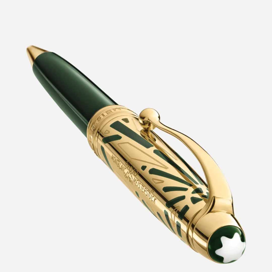 The Montblanc Meisterstück The Origin Collection Doue Classique Ballpoint Pen is a luxurious writing instrument in green and gold, adorned with intricate Art Déco designs. It features a curved clip, a distinctive star emblem on the cap, and has "Montblanc Meisterstück" engraved on it, set against a plain light background.
