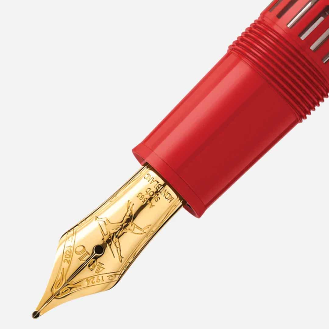 Close-up of a Montblanc Meisterstück X Olympic Heritage Paris 1924 Le Grand fountain pen nib, featuring intricate engravings, attached to a red pen body against a plain background.