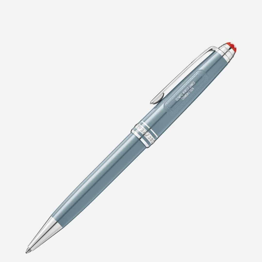 The Montblanc Meisterstück X Olympic Heritage Chamonix 1924 Classique ballpoint pen showcases a sleek design with blue and silver elements, complemented by a red accent on the cap. Equipped with a clip and metallic details, this pen elegantly honors timeless craftsmanship against a simple white background.